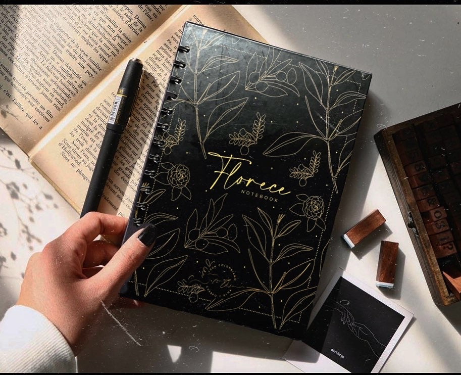 Florece Notebook — cuaderno negro con flores doradas